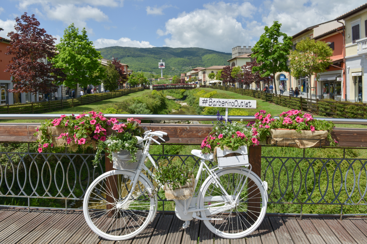 Barberino Designer Outlet — flower-lined bridge in the open-air outlet village, Tuscany Italy