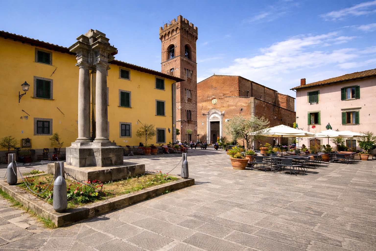 Piazza del Comune in Montecarlo with stone columns, medieval bell tower and outdoor café tables, Tuscany Italy