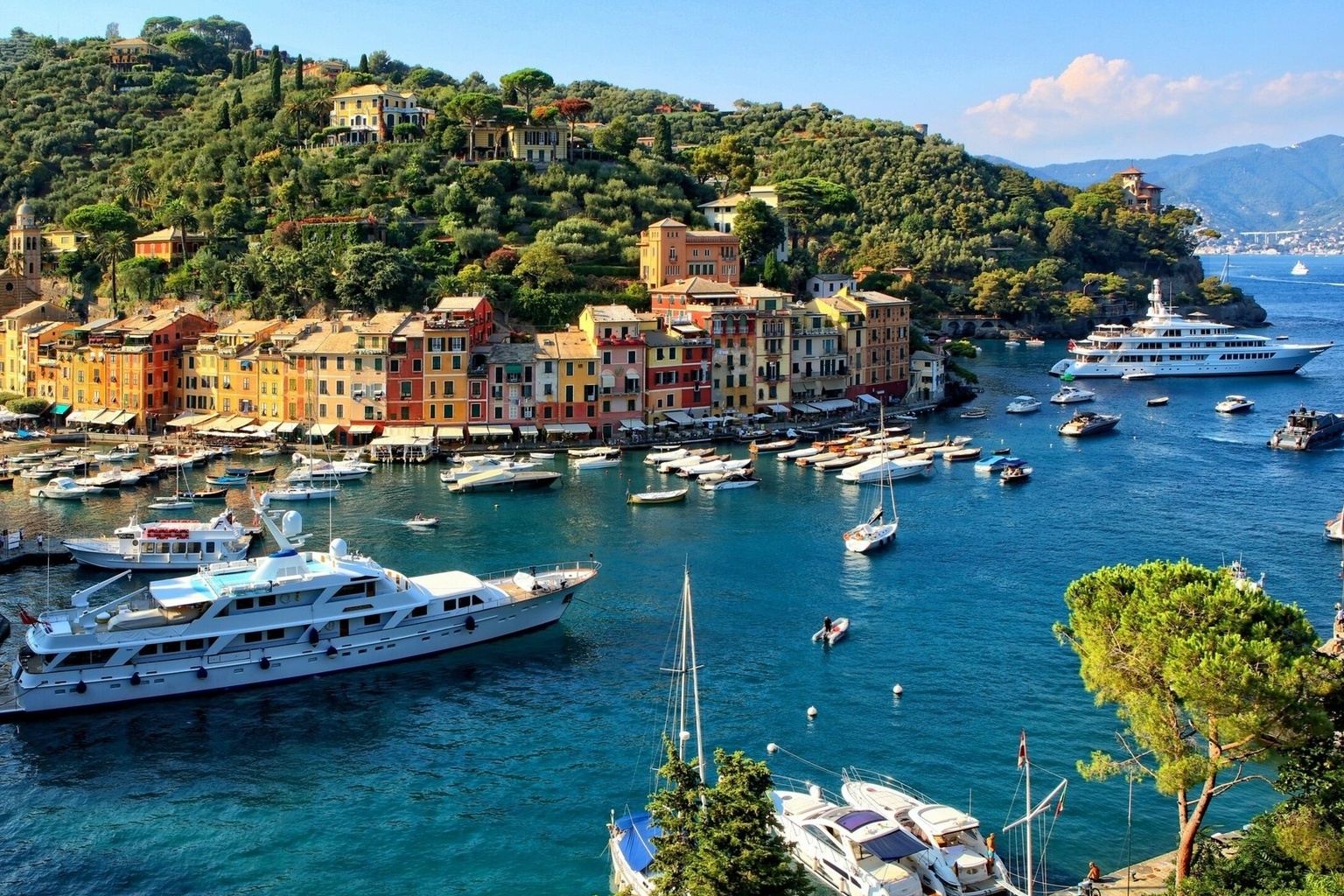 Aerial panoramic view of Portofino harbour with luxury superyachts, colourful pastel buildings and turquoise water, Italian Riviera Liguria Italy