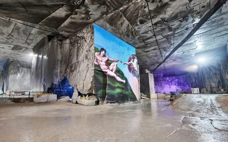 Inside Fantiscritti marble cave with Michelangelo's Creation of Adam painted on the wall