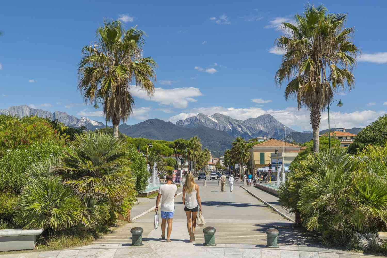 Forte dei Marmi promenade with palm trees and Apuan Alps backdrop — private chauffeur transfer Tuscany